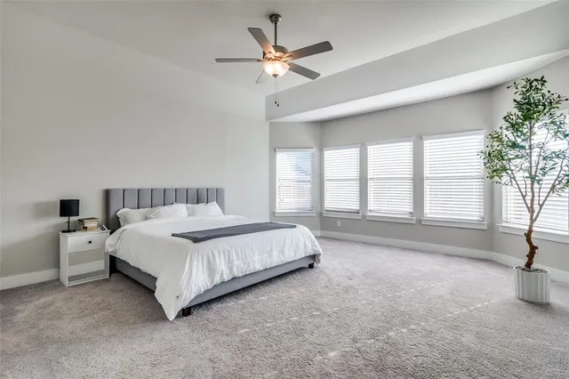 a spacious bedroom with a bed and a large window