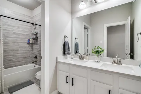 a bathroom with a bathtub shower sink vanity and toilet