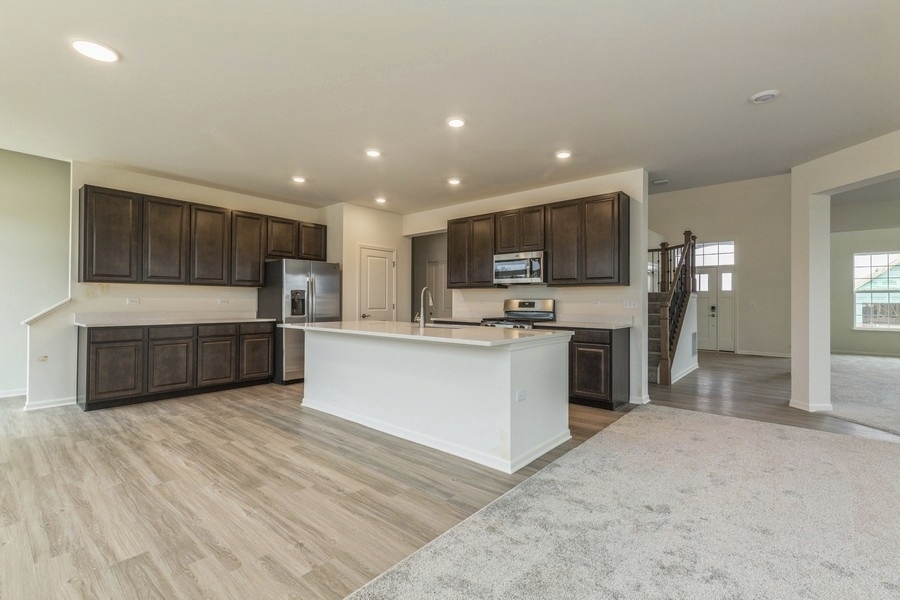 3616 Edelweiss Road Elgin, IL 60124 - Photo 7 of 26 a large kitchen with a large counter top stainless steel appliances and cabinets