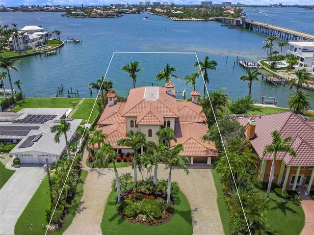 a view of a big house with a big yard plants and palm trees