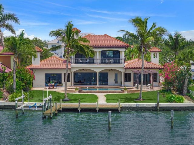 a front view of a house with a yard and potted plants