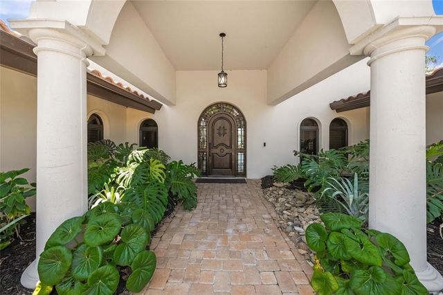 a kitchen with stainless steel appliances granite countertop a refrigerator a sink dishwasher a stove and a dining table with wooden floor