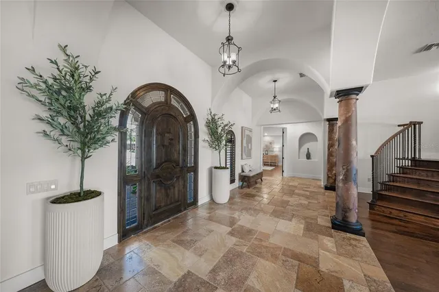 a kitchen with stainless steel appliances granite countertop a table chairs and a refrigerator