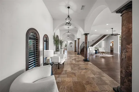 a kitchen with a stove center island wooden floor and living room view