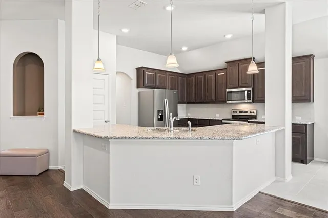 a kitchen with stainless steel appliances granite countertop a sink refrigerator and cabinets