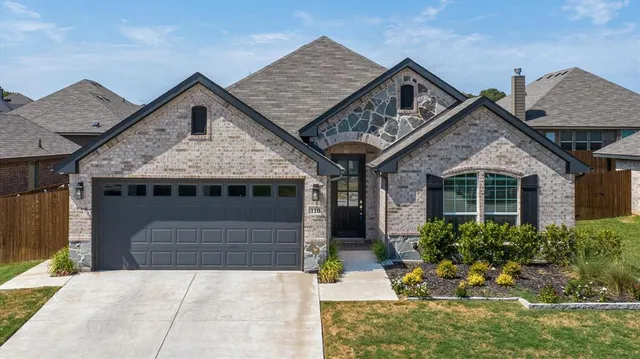 a front view of a house with a garden and plants