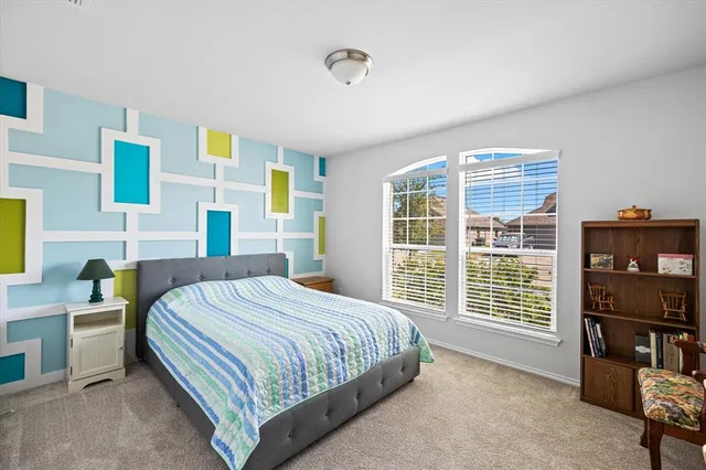 a bedroom with a bed and a flat tv screen next to a window