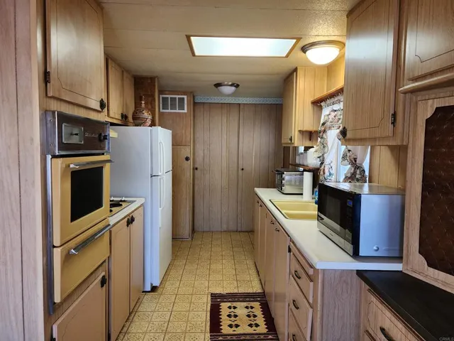 a kitchen with stainless steel appliances granite countertop a refrigerator a stove and a sink