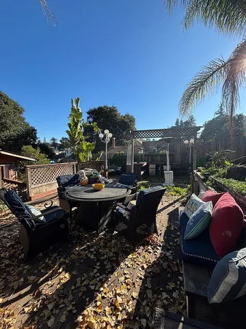 a view of a patio with table and chairs potted plants and palm tree