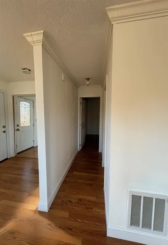 a view of a hallway with wooden floor and entryway