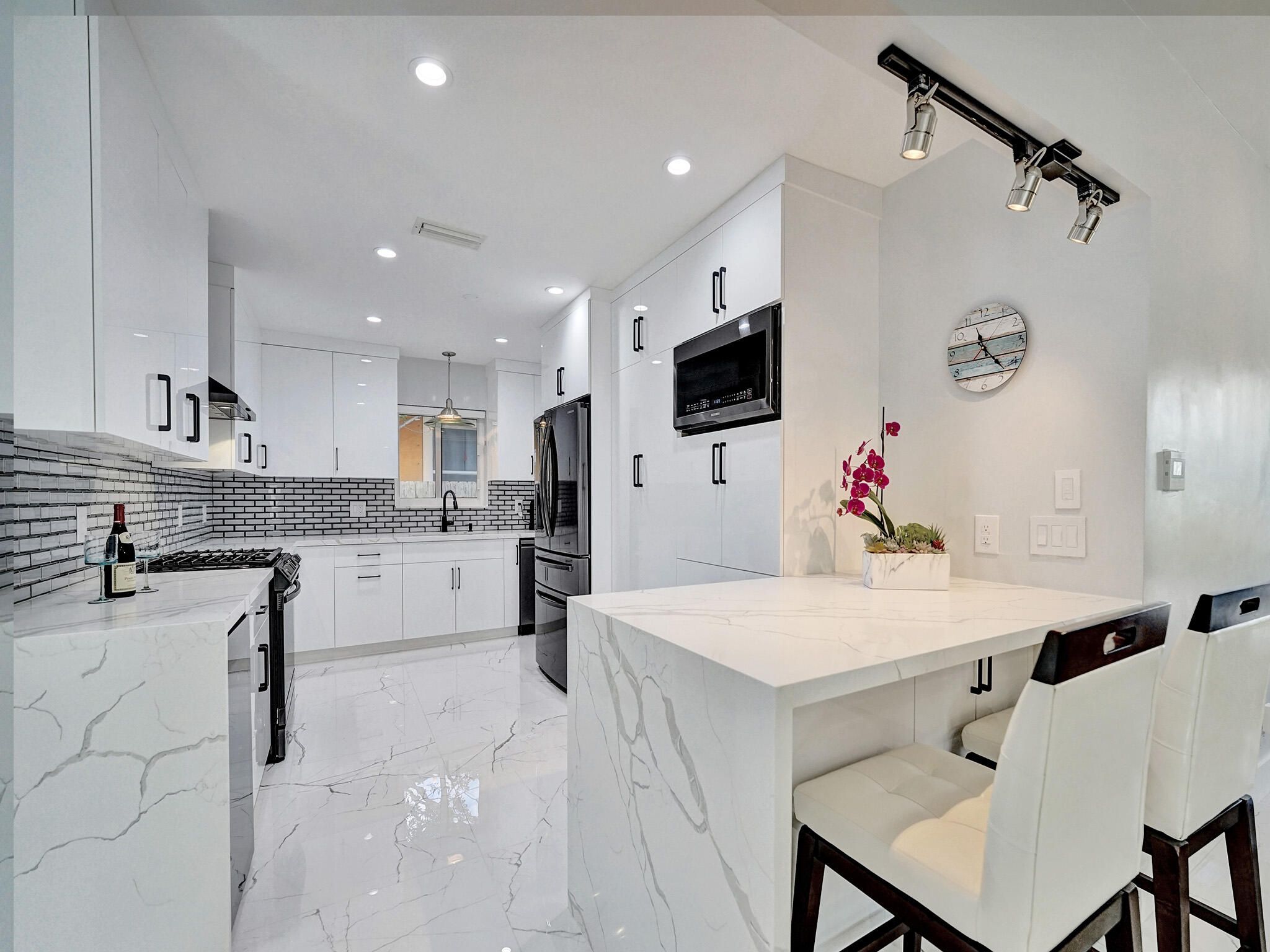 3204 Robbins Road Pompano Beach, FL 33062 - Photo 14 of 37 a kitchen with a white center island and cabinets