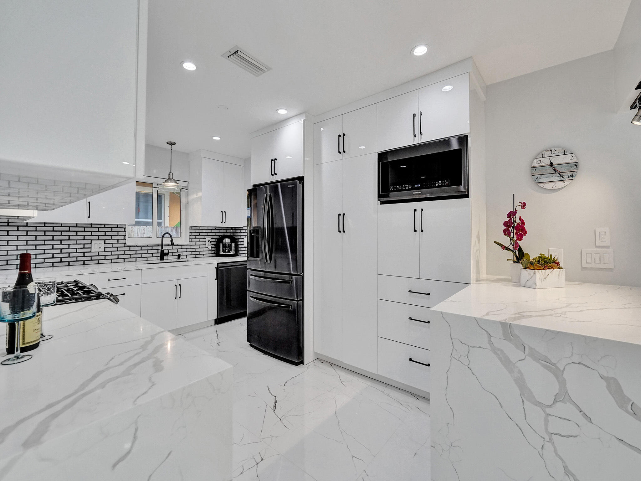3204 Robbins Road Pompano Beach, FL 33062 - Photo 15 of 37 a kitchen with white cabinets and stainless steel appliances