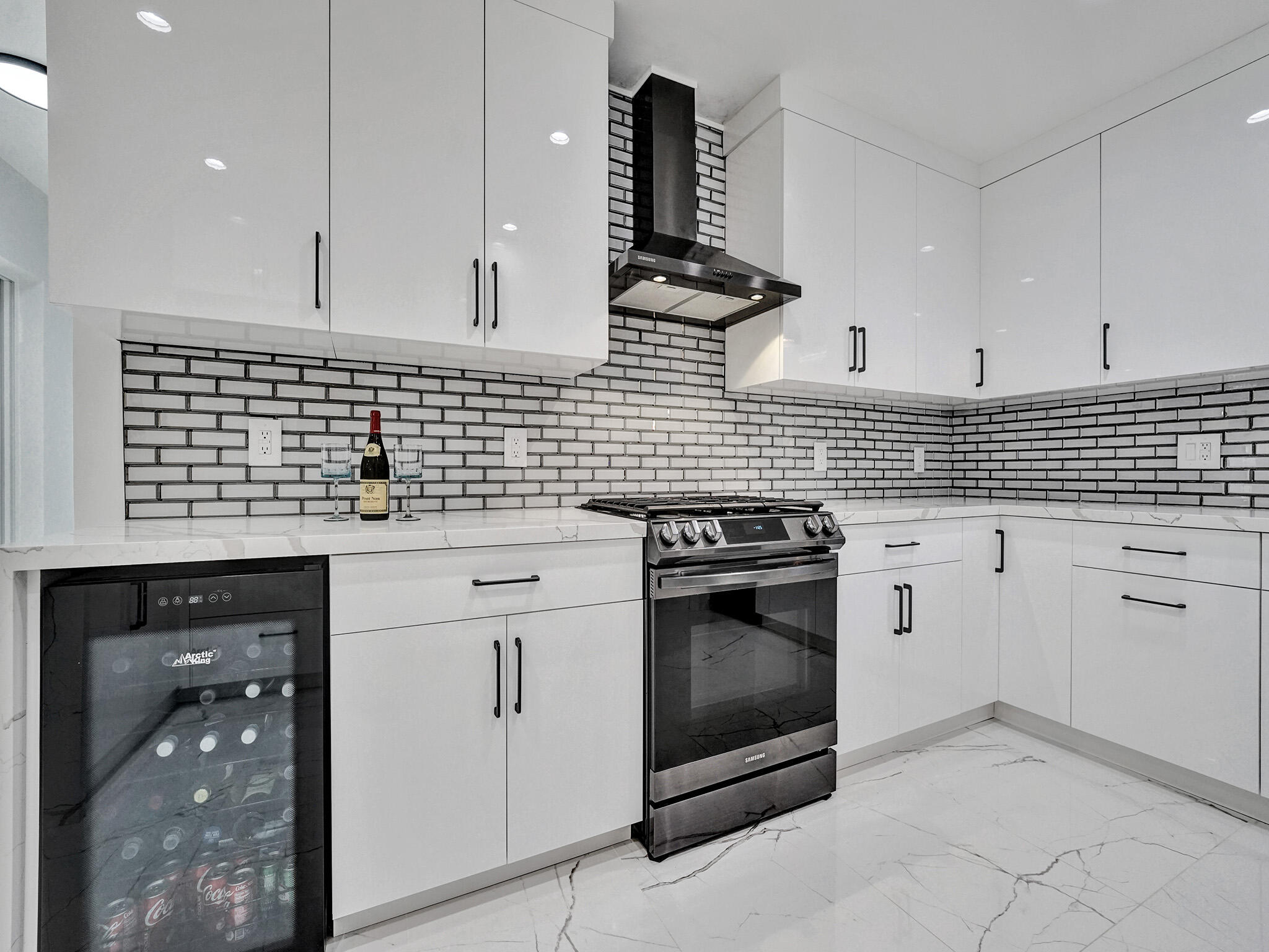 3204 Robbins Road Pompano Beach, FL 33062 - Photo 17 of 37 a kitchen with white cabinets and appliances