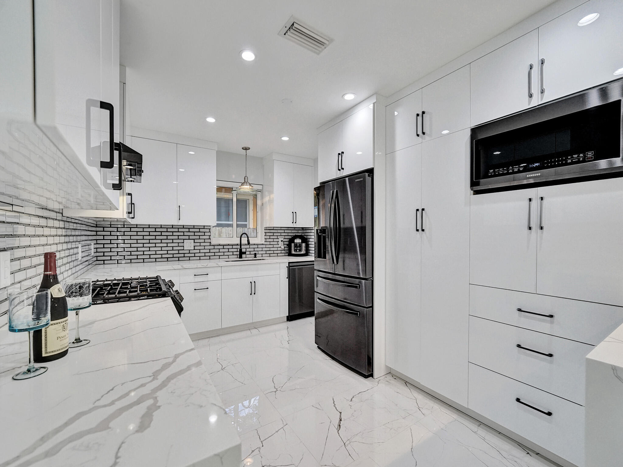 3204 Robbins Road Pompano Beach, FL 33062 - Photo 18 of 37 a kitchen with granite countertop white cabinets and stainless steel appliances