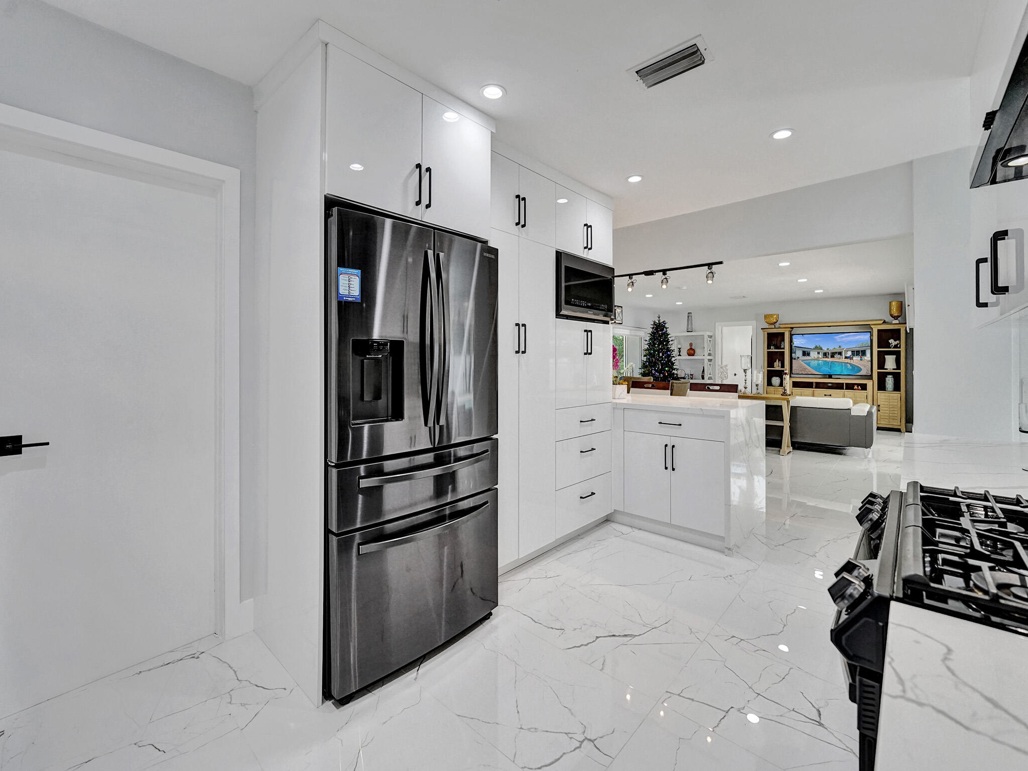 3204 Robbins Road Pompano Beach, FL 33062 - Photo 19 of 37 a kitchen with stainless steel appliances a refrigerator sink and cabinets