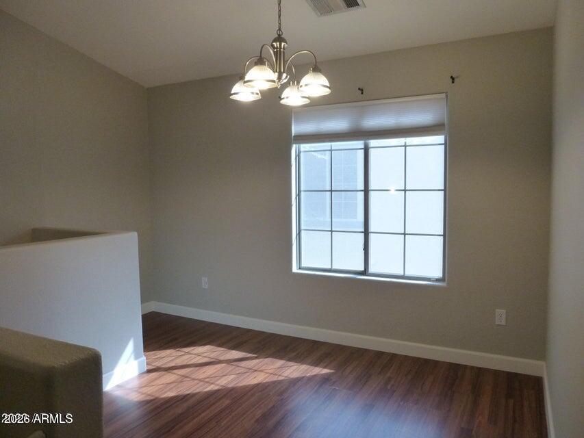 2727 North Price Road, Unit 28 Chandler, AZ 85224 - Photo 3 of 14 a view of an empty room with wooden floor and a window