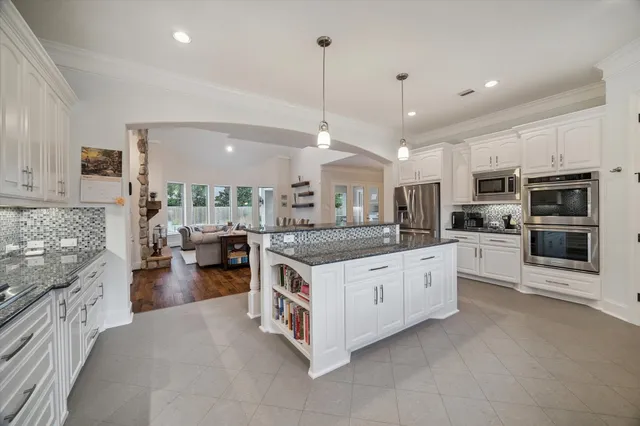 a kitchen with stainless steel appliances granite countertop a stove and a sink