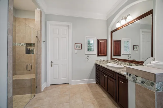 a spacious bathroom with a double vanity sink a mirror and a shower