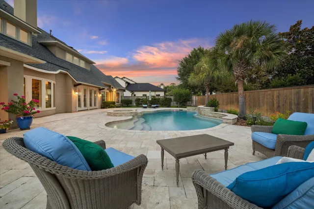 a view of a house with pool and chairs
