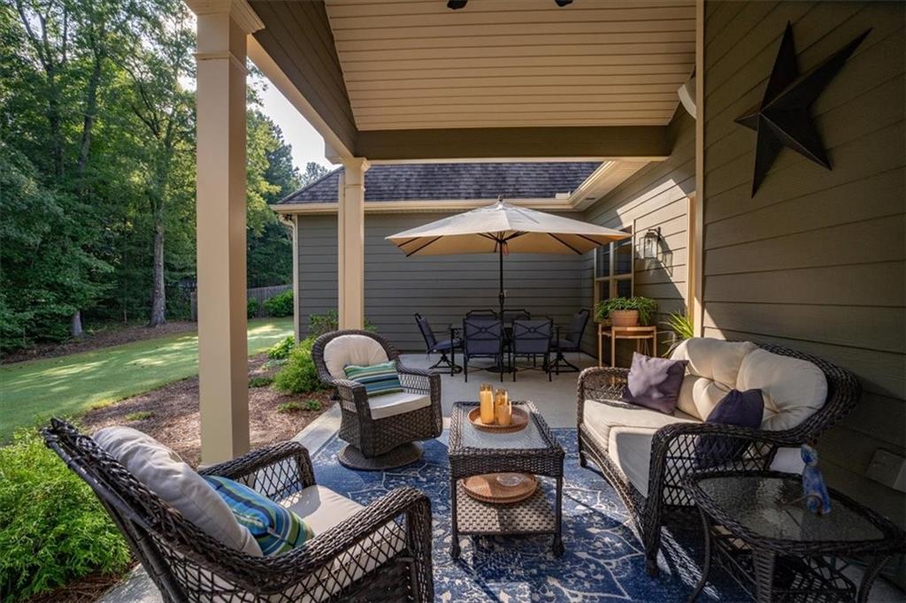 3065 Brooks Trail Monroe, GA 30656 - Photo 45 of 80 a view of a patio with a dining table and chairs under an umbrella