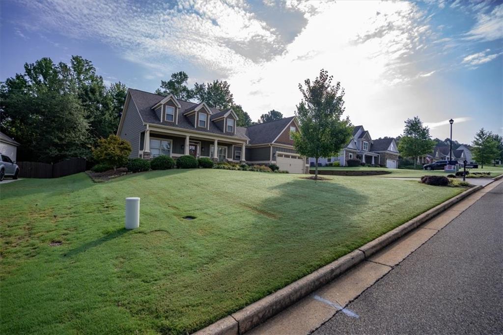 3065 Brooks Trail Monroe, GA 30656 - Photo 59 of 80 a view of a white house with a big yard and potted plants