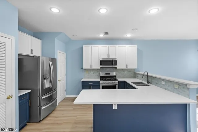 a kitchen with stainless steel appliances a refrigerator sink and microwave