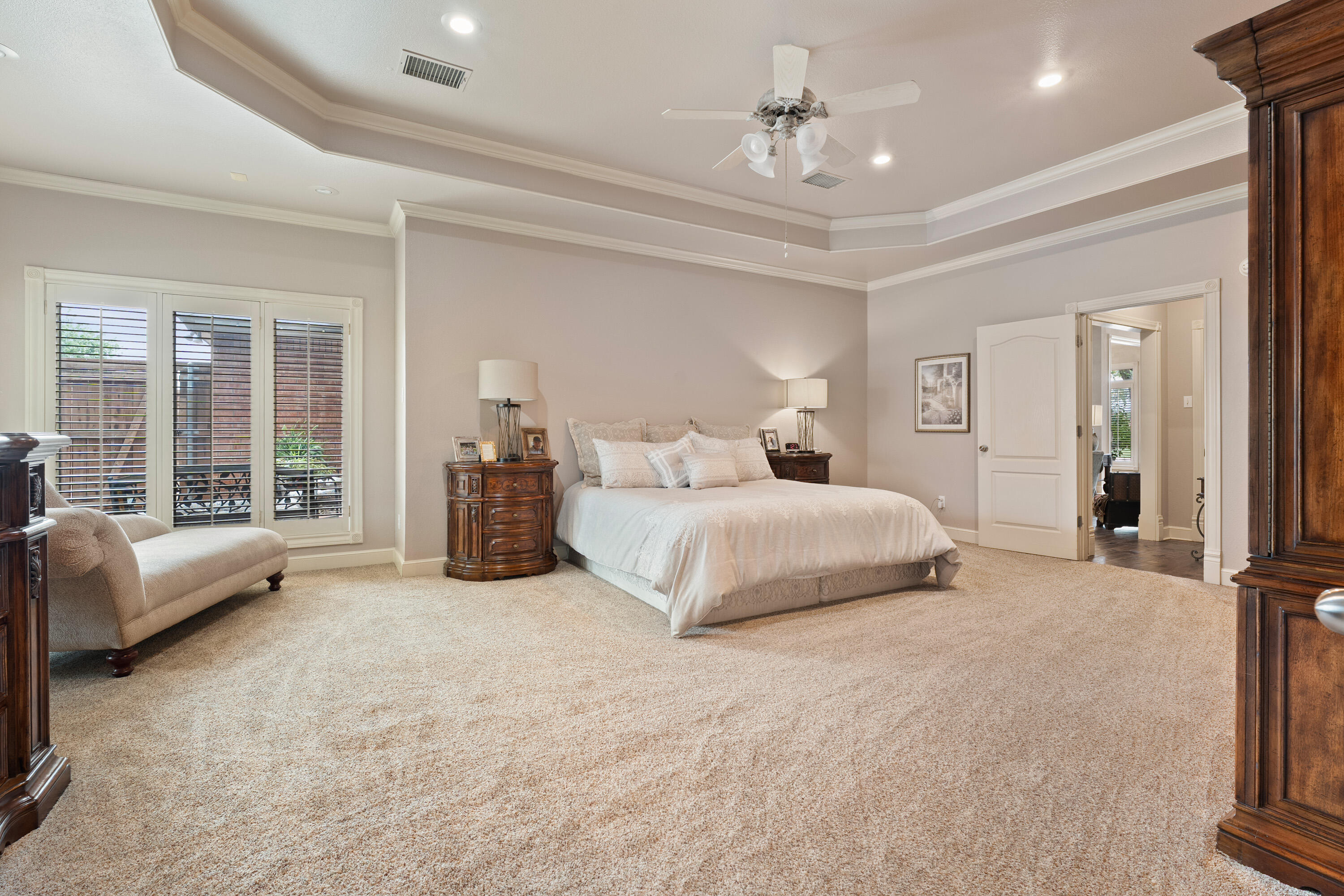 4813 101st Street Lubbock, TX 79424 - Photo 11 of 31 a spacious bedroom with a bed a couch and large window