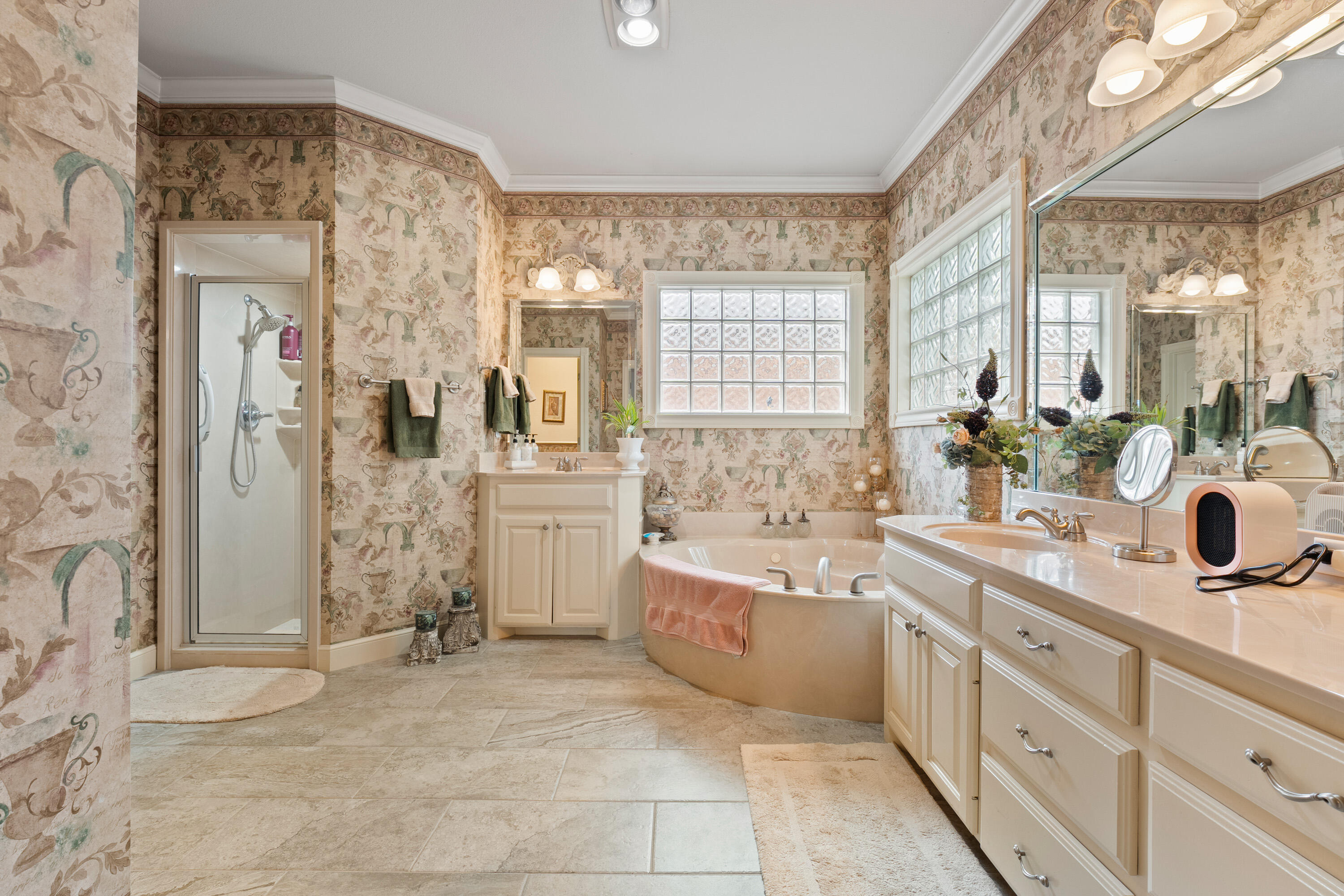 4813 101st Street Lubbock, TX 79424 - Photo 12 of 31 a spacious bathroom with a double vanity sink a large mirror and a bathtub