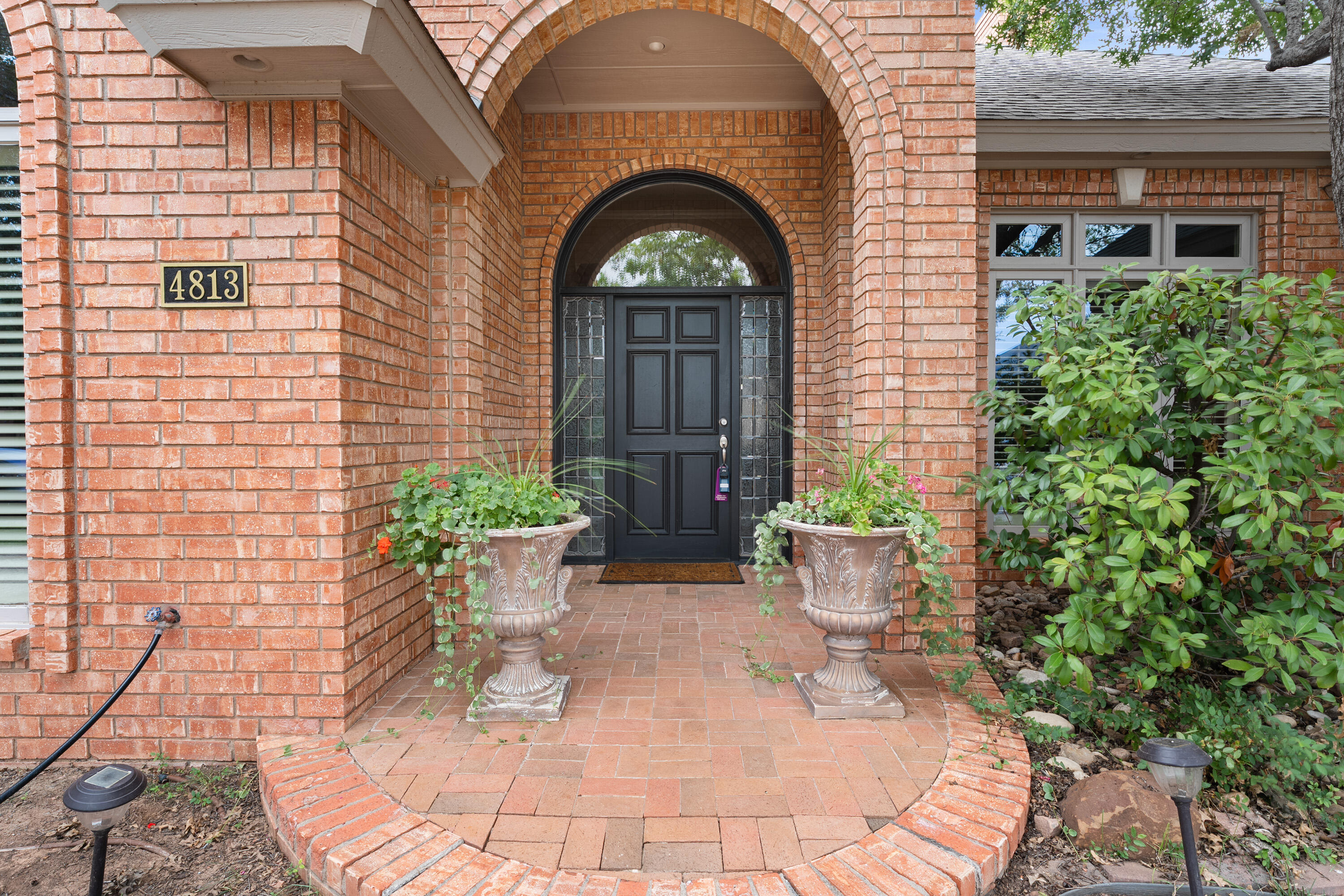 4813 101st Street Lubbock, TX 79424 - Photo 2 of 31 a front view of a house with potted plants