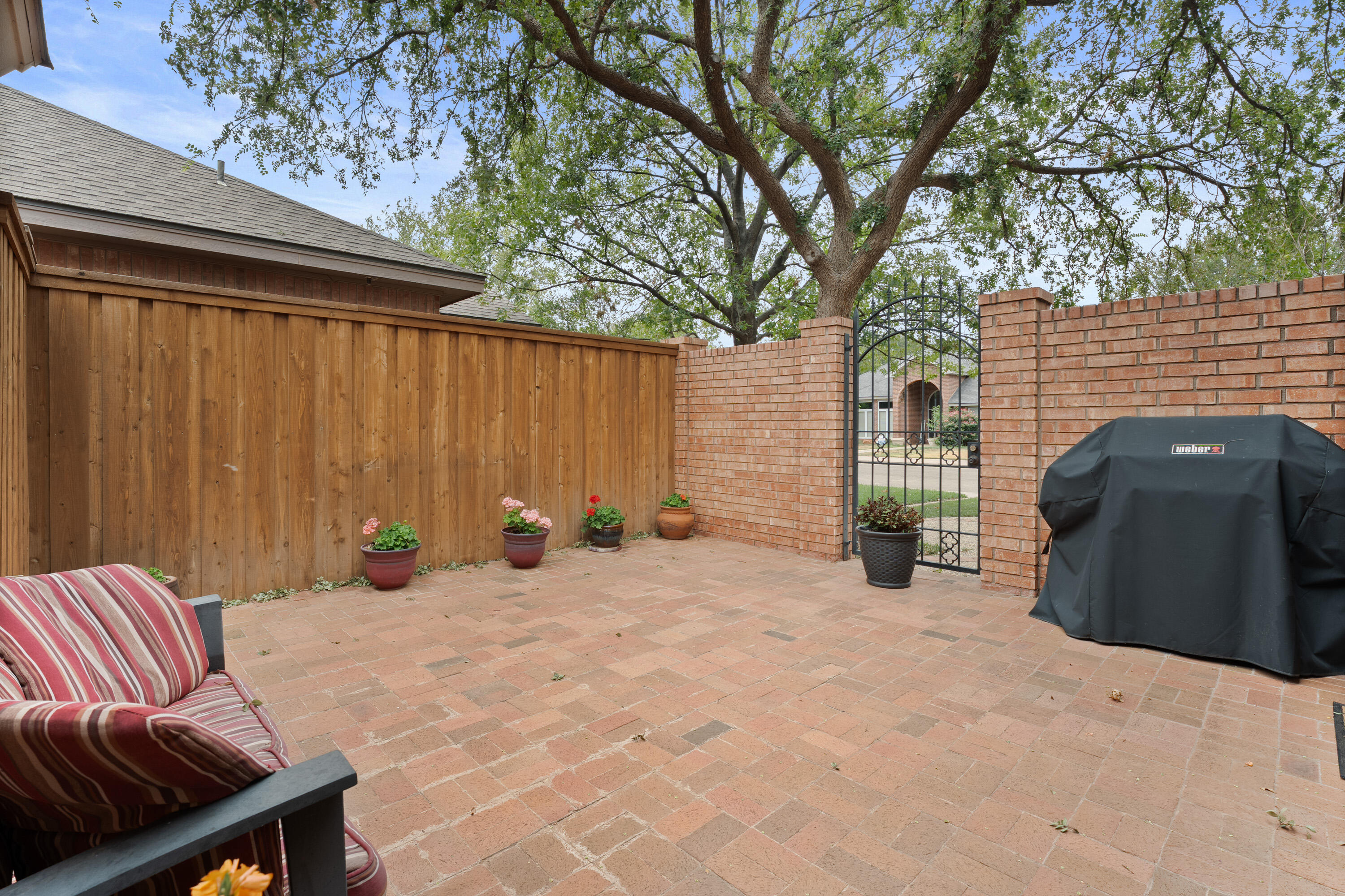 4813 101st Street Lubbock, TX 79424 - Photo 26 of 31 a view of a backyard with couches and a large tree
