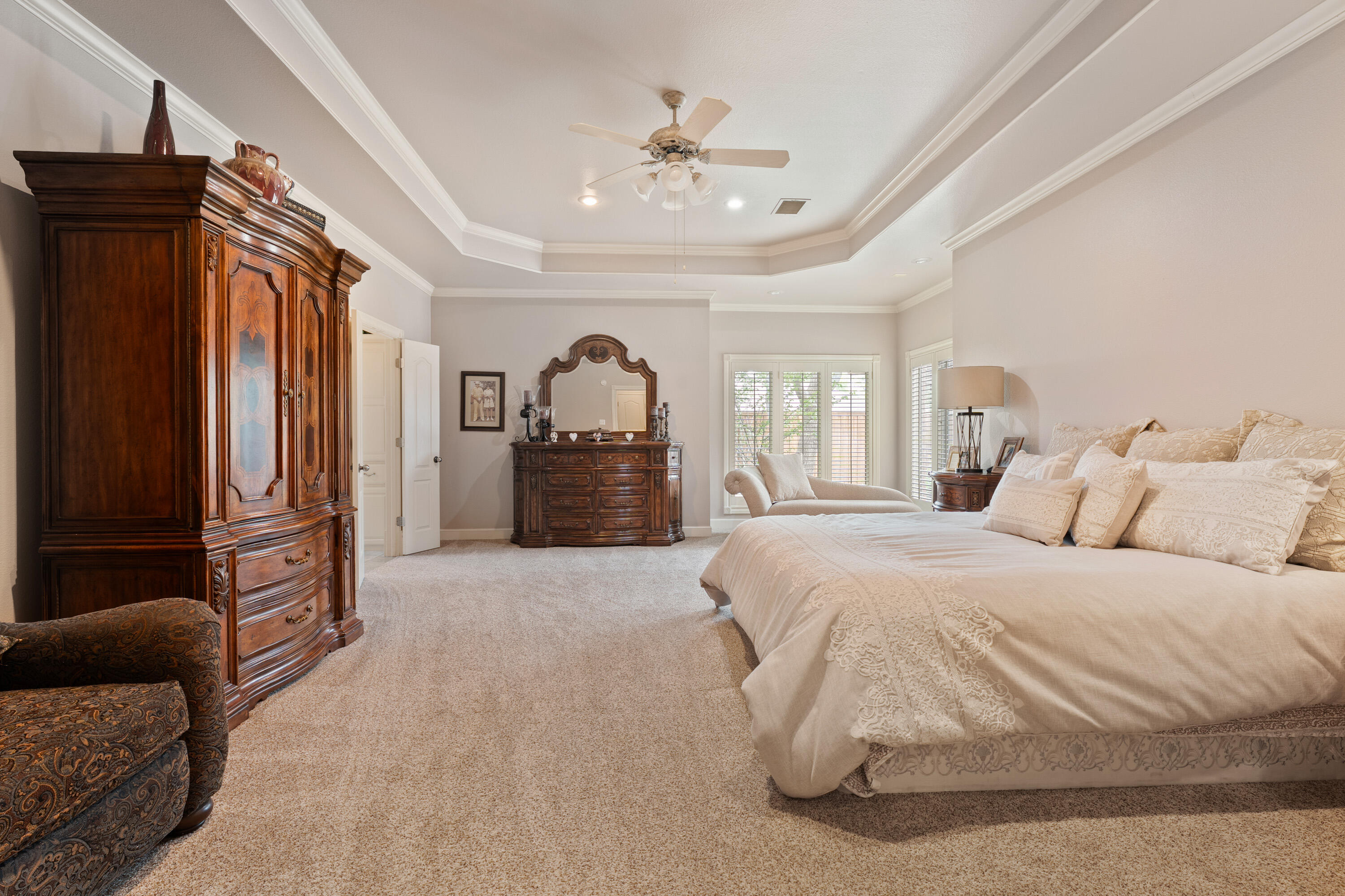4813 101st Street Lubbock, TX 79424 - Photo 10 of 31 a spacious bedroom with a bed a couch and dresser