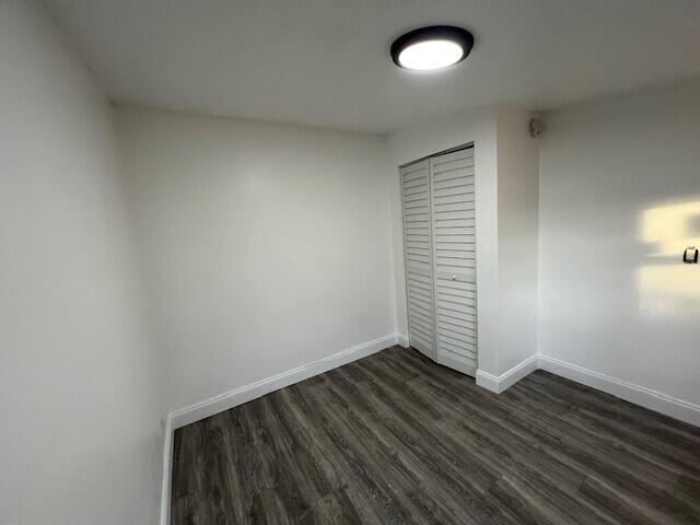 920 Haverhill Road, Unit 1B Haverhill, FL 33415 - Photo 2 of 6 an empty room with wooden floor and windows