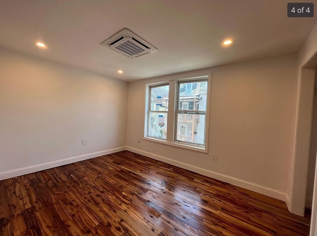 155 Orange Street, Unit B Chelsea, MA 02150 - Photo 4 of 4 a view of an empty room with wooden floor and a window