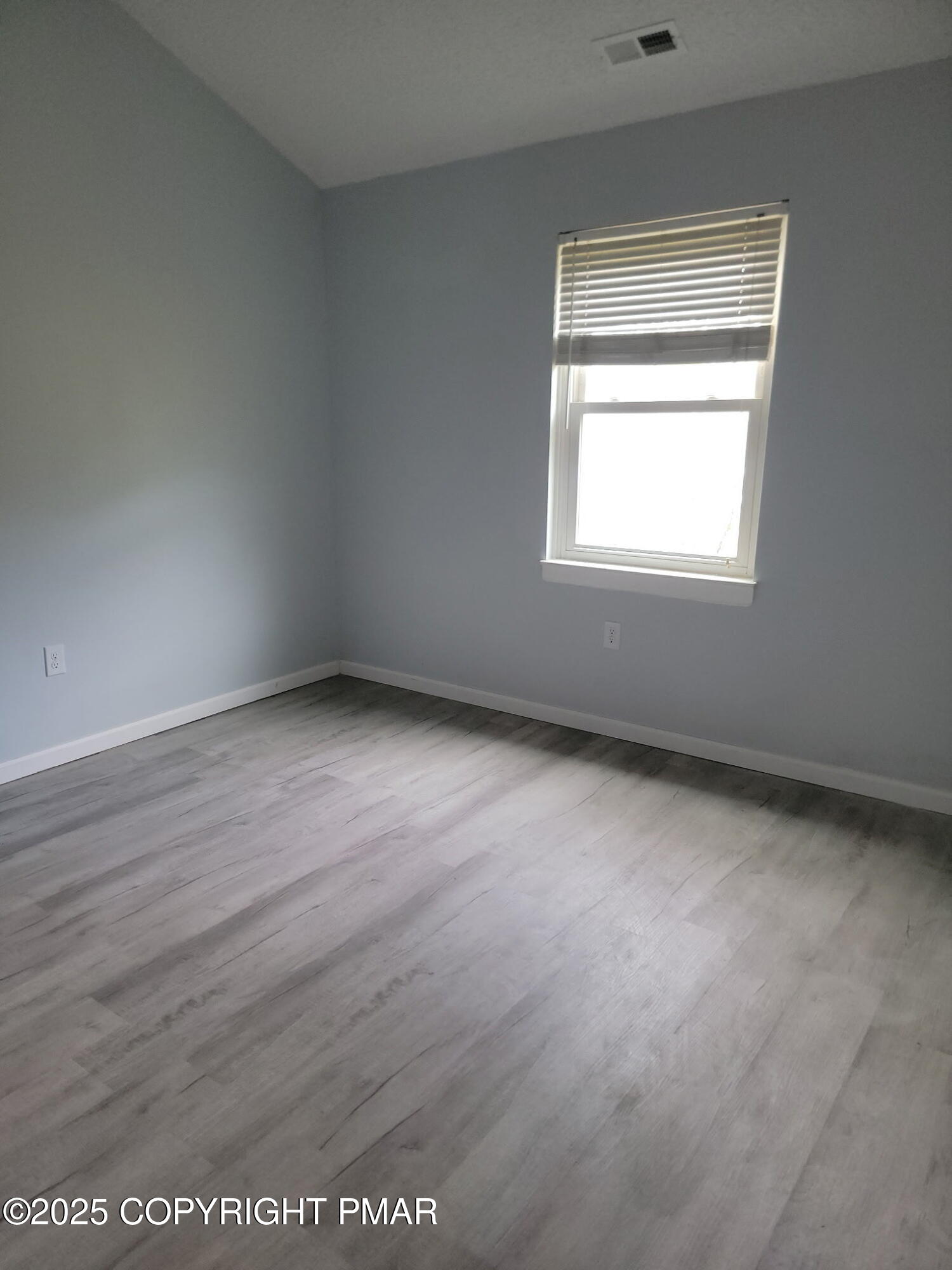 151 Snowshoe Court, Unit 204 Mount Pocono, PA 18344 - Photo 7 of 8 an empty room with wooden floor and windows