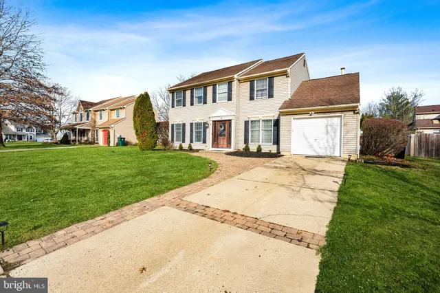 a front view of a house with a garden and yard