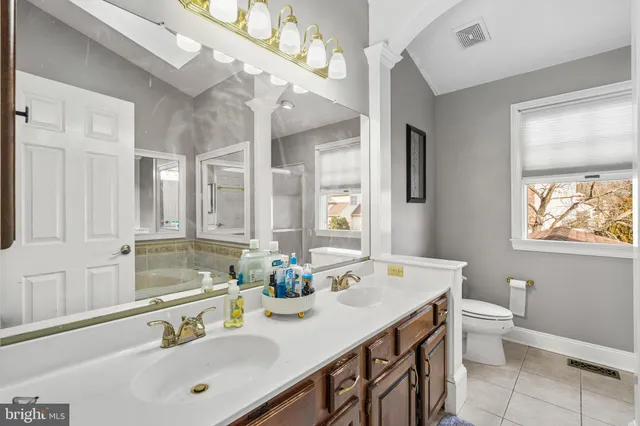 a bathroom with a double vanity sink toilet and a mirror