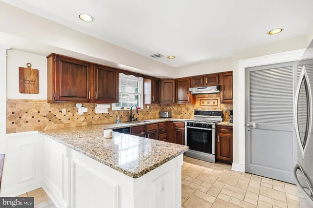 a kitchen with stainless steel appliances granite countertop a sink stove and refrigerator