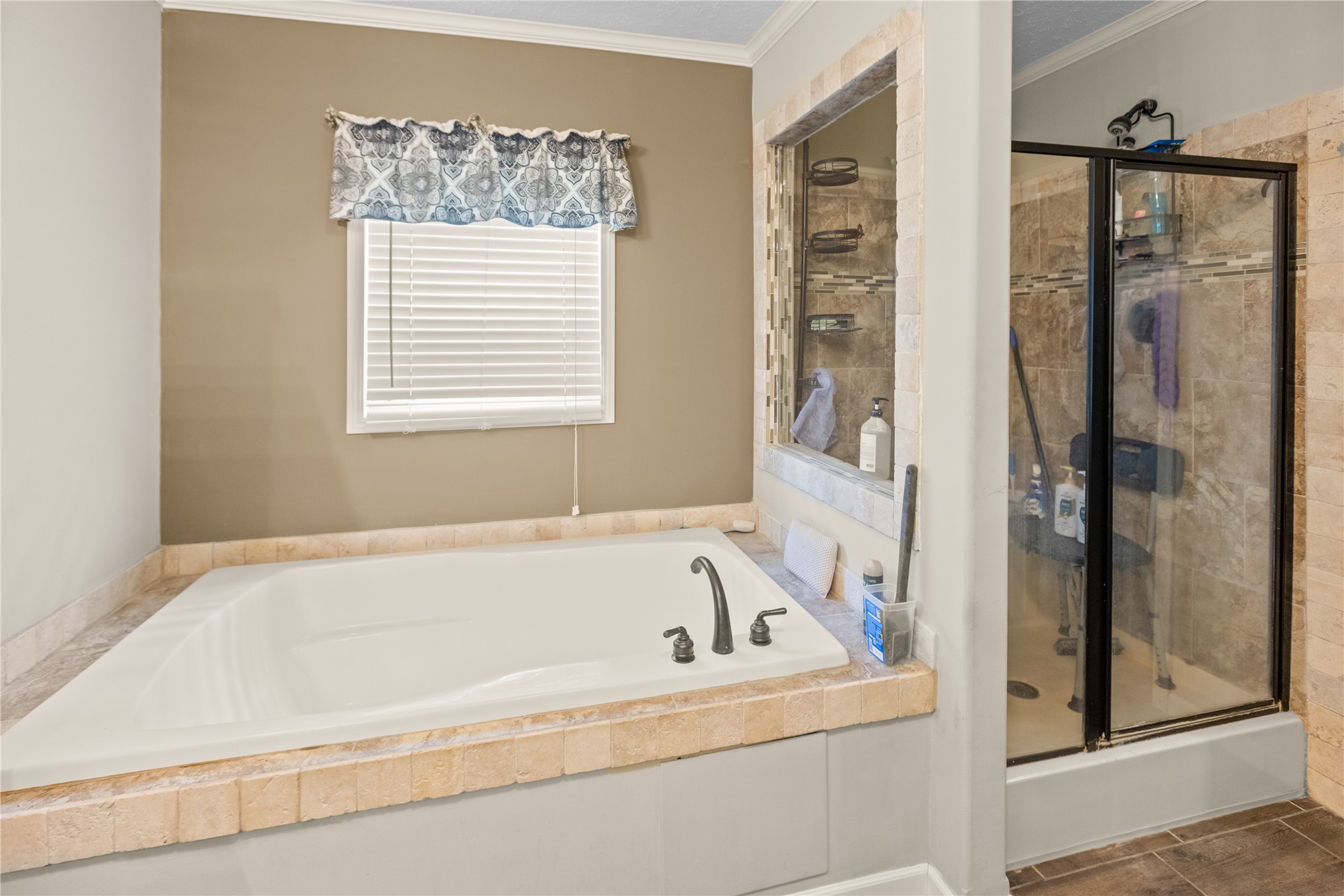 1800 2110th Road Hugo, OK 74743 - Photo 14 of 27 Built-in soaking tub with dark-finish fixtures, tile surround, and a separate glass-enclosed shower featuring tiled walls