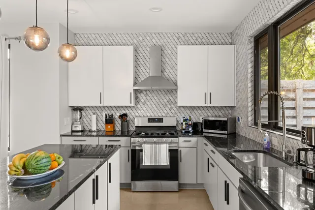 a kitchen with granite countertop a stove a sink and a granite counter tops