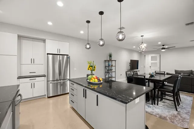 a kitchen with stainless steel appliances granite countertop a sink a stove and a wooden floors