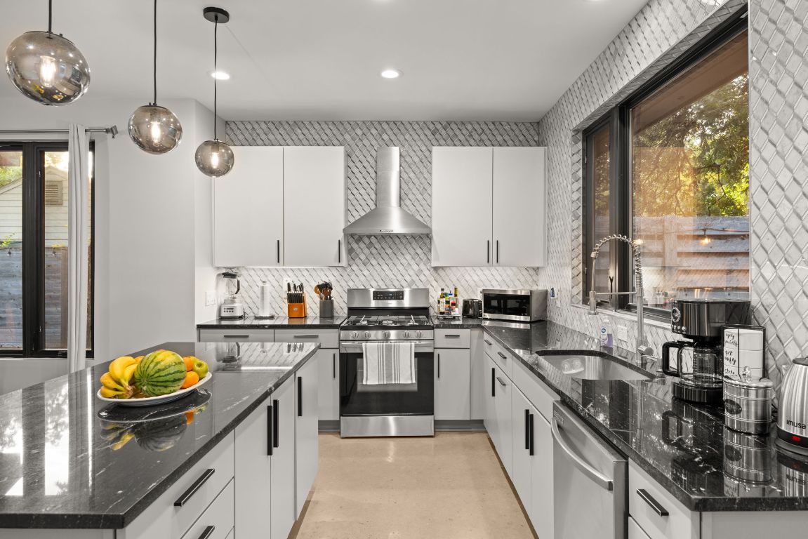 3610 Thompson Street, Unit 1 Austin, TX 78702 - Photo 18 of 39 a kitchen with stainless steel appliances granite countertop sink stove and cabinets