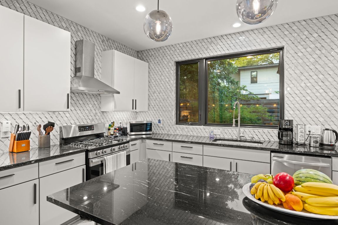 3610 Thompson Street, Unit 1 Austin, TX 78702 - Photo 20 of 39 a kitchen with stainless steel appliances granite countertop a sink a stove and a wooden cabinets