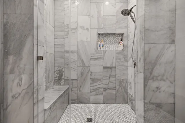 a bathroom with a double vanity sink mirror and shower