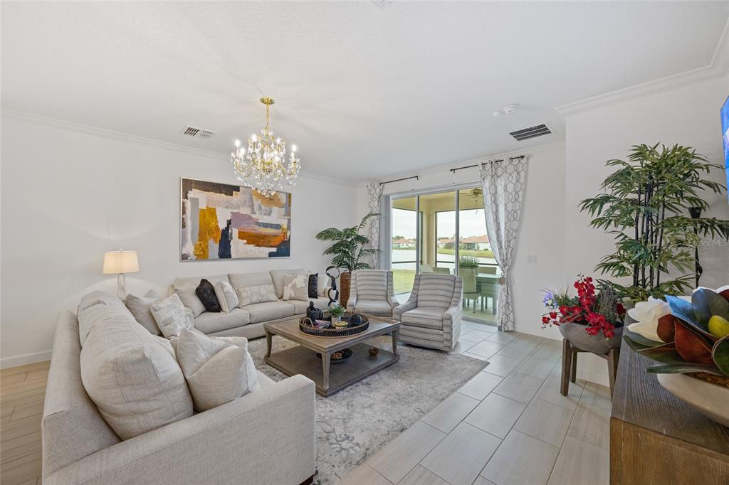 5513 Little Path Drive Wimauma, FL 33598 - Photo 16 of 40 a living room with furniture and a chandelier