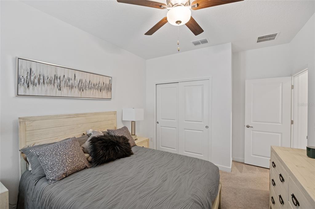 5513 Little Path Drive Wimauma, FL 33598 - Photo 25 of 40 a bedroom with a bed and a chandelier