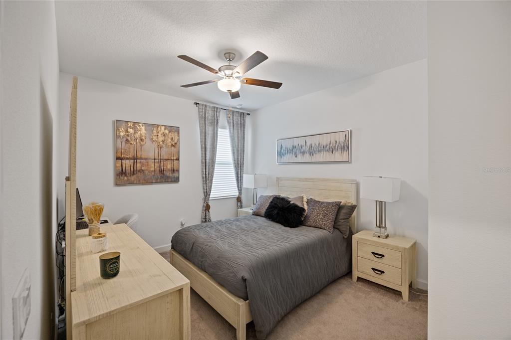 5513 Little Path Drive Wimauma, FL 33598 - Photo 26 of 40 a bedroom with a bed and a chandelier