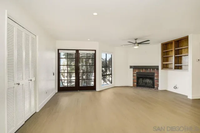 a view of an empty room with a fireplace and a window