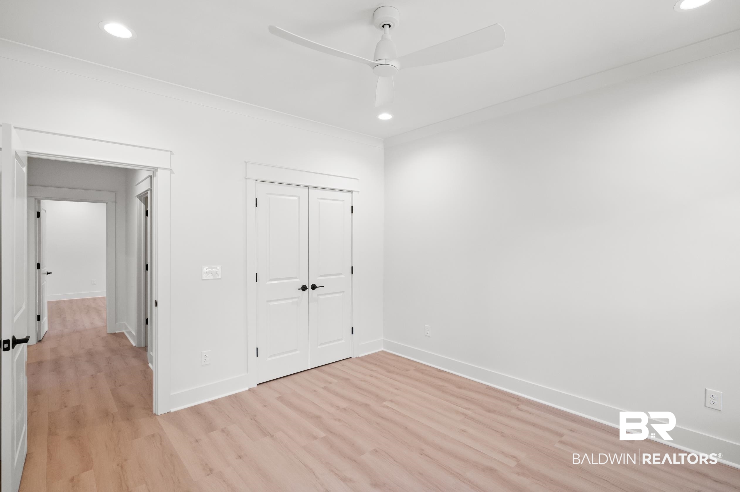 28889 Canal Road Orange Beach, AL 36561 - Photo 24 of 55 Unfurnished bedroom with ceiling fan, light wood-type flooring, and a closet