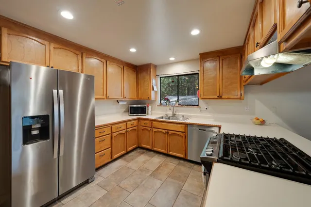 a kitchen with granite countertop stainless steel appliances a refrigerator a sink a stove a microwave and cabinets