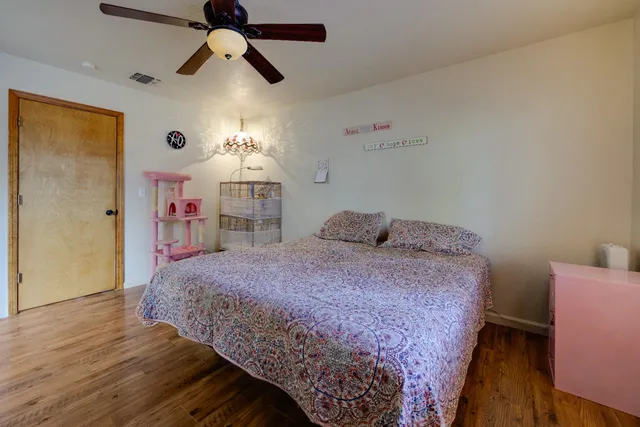 a spacious bedroom with a bed and a chandelier